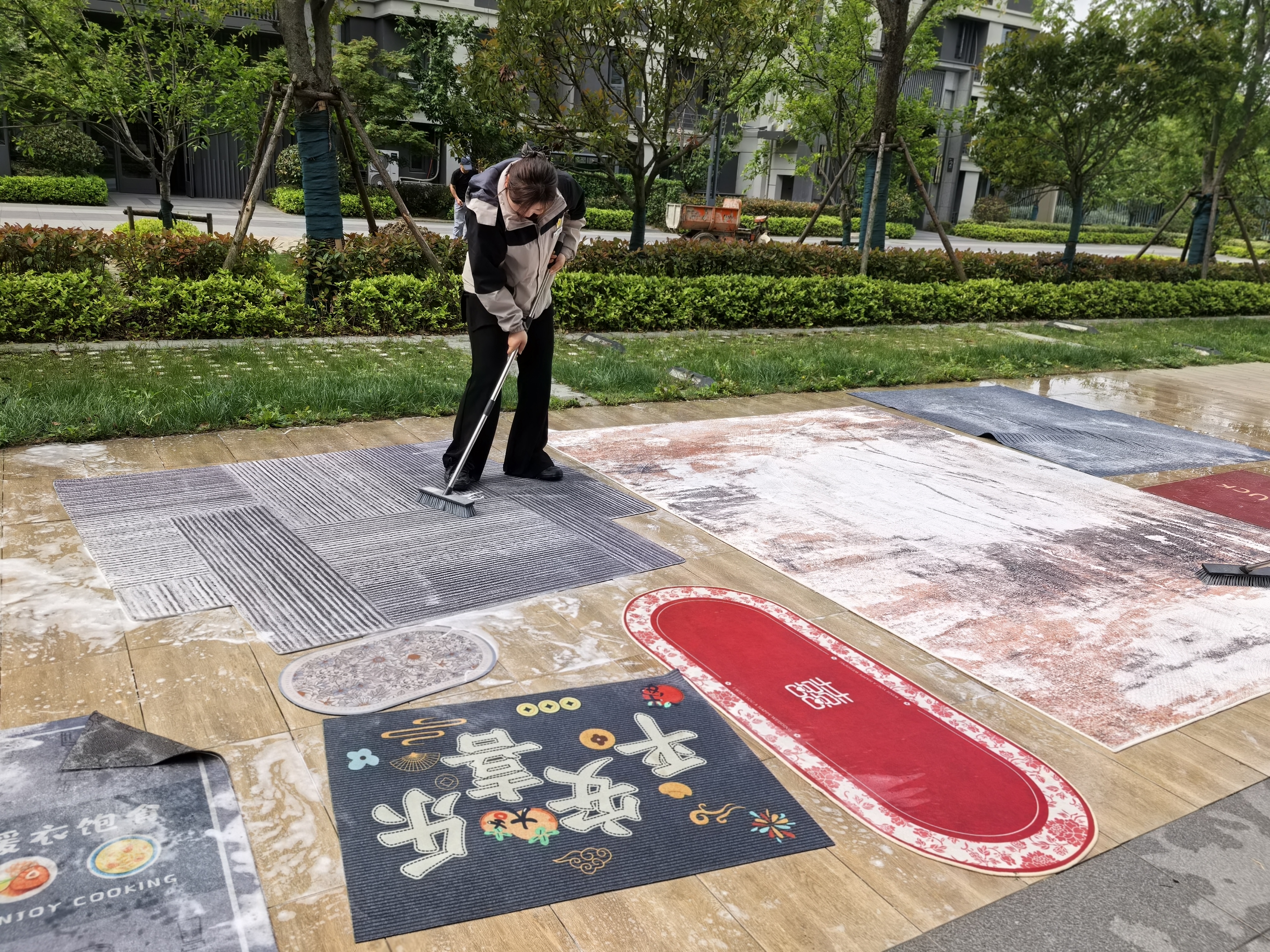 阜阳港龙置业物业人员在小某户外清洗业主入户地垫