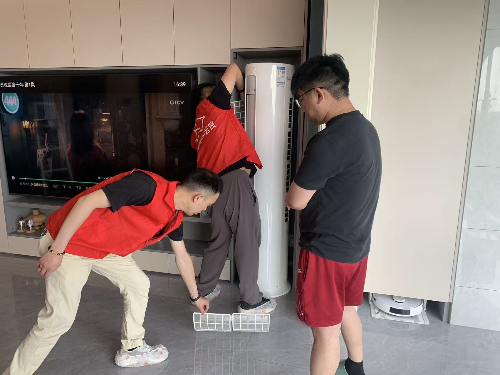 阜阳港龙置业旗下云筑工作人员上门为业主清洁空调滤网，业主在场监督