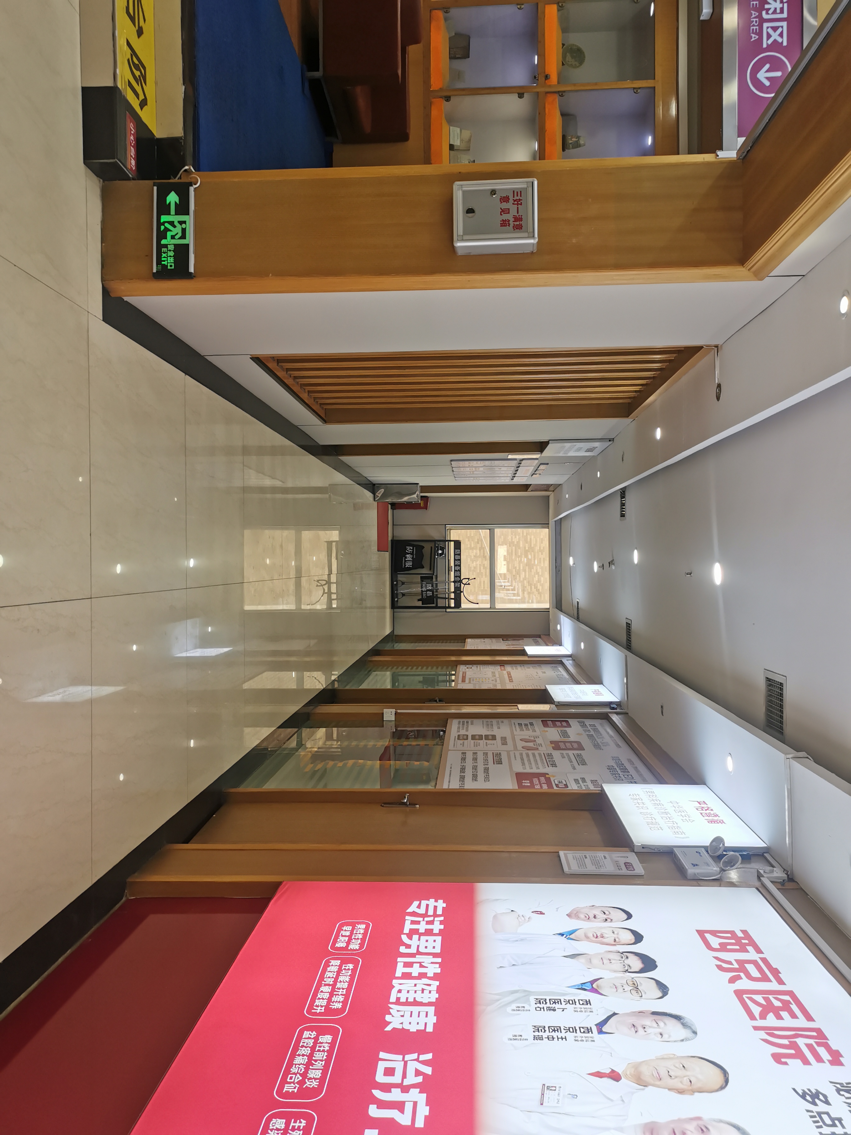 咸阳秦都九龙医院内部走廊设男科宣传海报，展示西京医院专家团队