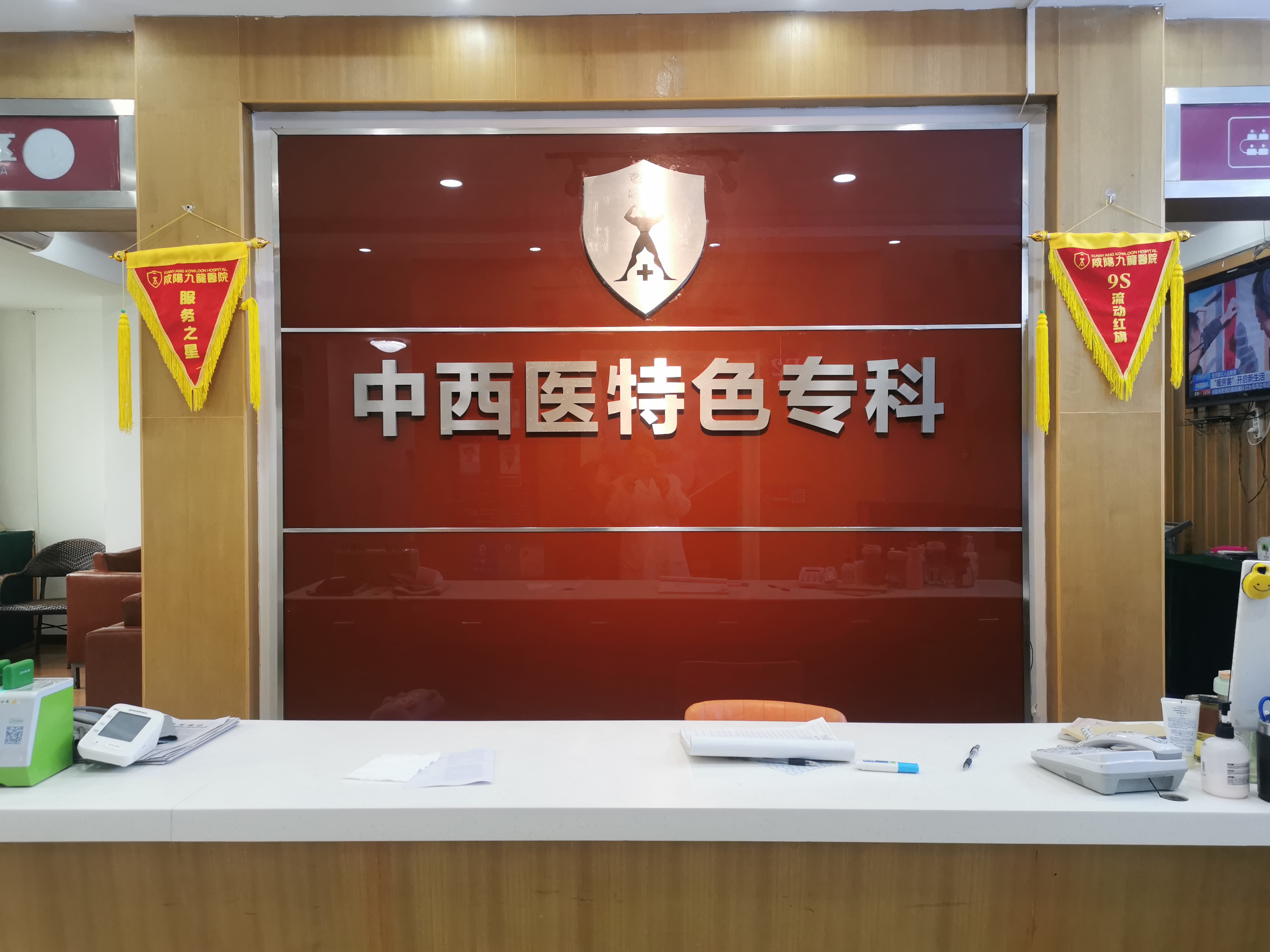 咸阳秦都九龙医院中西医特色专科前台，挂有服务类锦旗