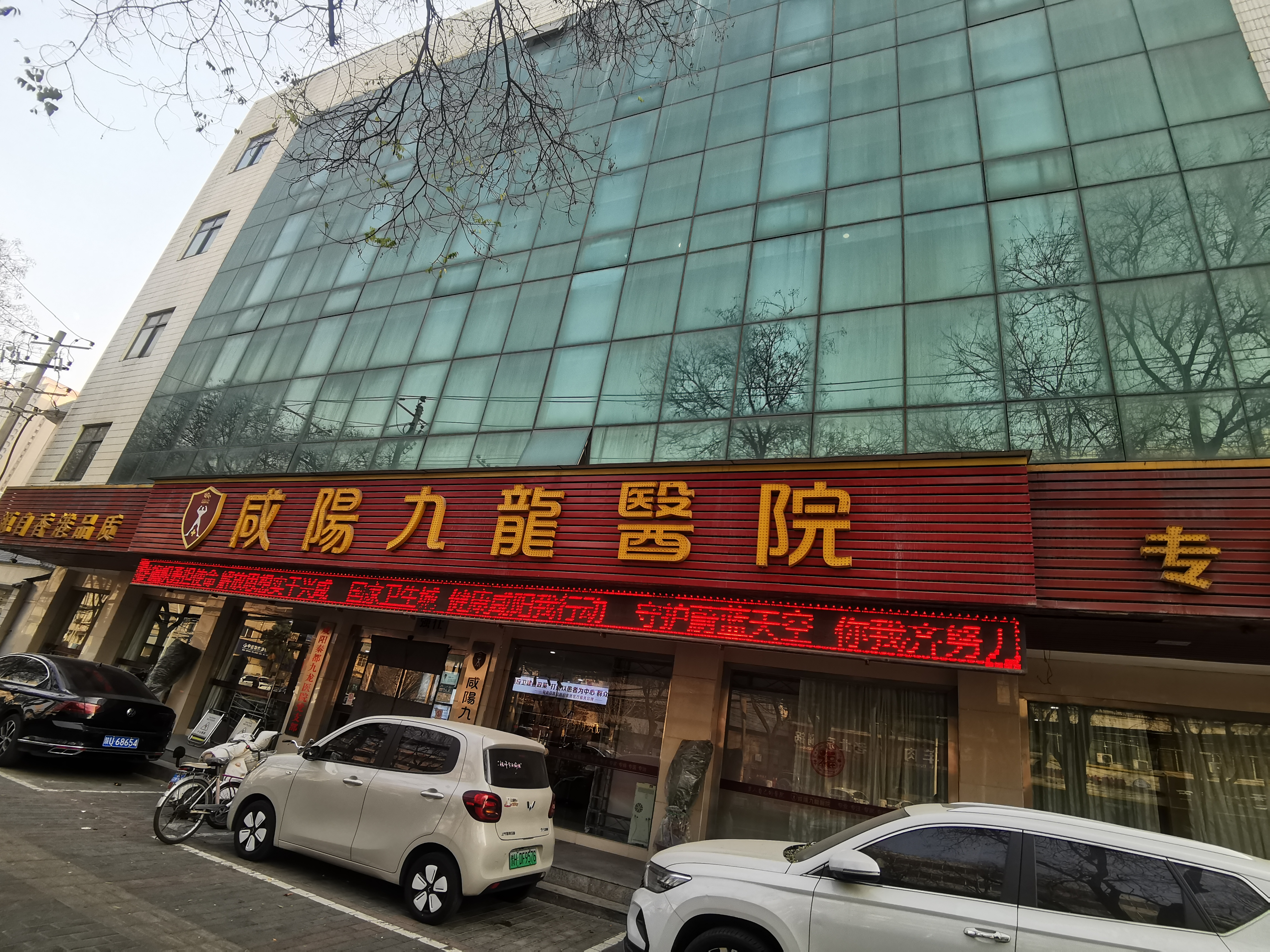 咸阳秦都九龙医院临街外观,电子屏展示健康宣传标语